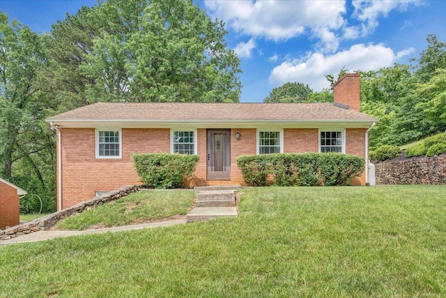 ranch-style house with brick siding, a chimney, and a front lawn