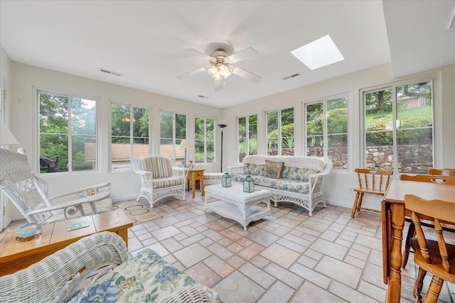 sunroom with a skylight, plenty of natural light, and baseboards