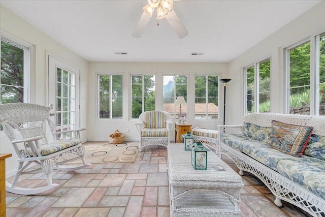 sunroom with plenty of natural light, baseboards, and stone finish flooring