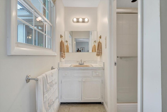 full bath featuring vanity, a shower, and baseboards