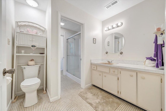 bathroom with a stall shower, vanity, toilet, and baseboards