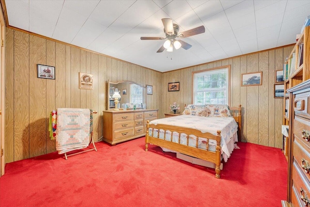 carpeted bedroom with wood walls and ceiling fan
