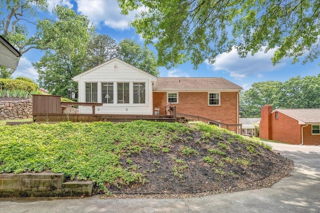 view of front of property featuring a deck and brick siding
