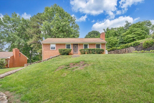 single story home featuring a front lawn, brick siding, and a chimney