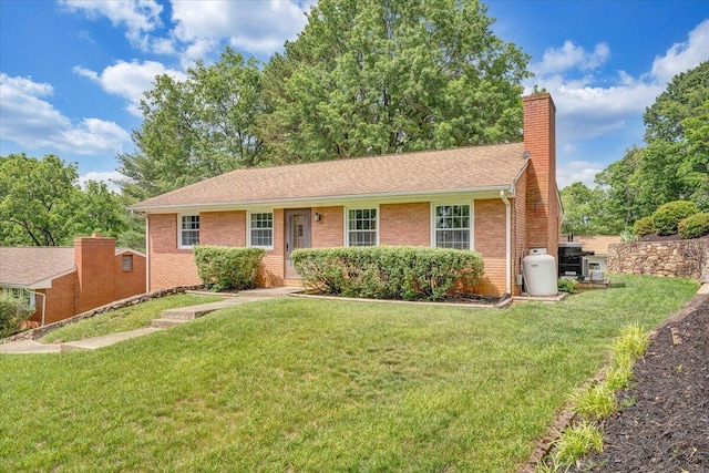 single story home with a chimney, a front yard, brick siding, and a shingled roof