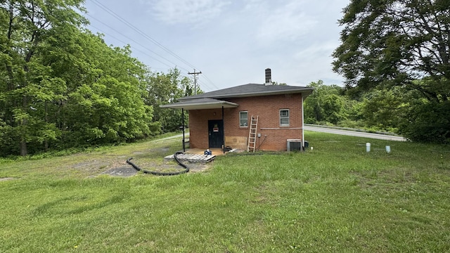 1050 Ashwell Cir, Huddleston, VA 24104 - rear view of property featuring brick siding, a lawn, central AC unit, and a chimney