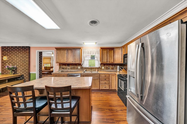 3643 Larson Ln, Roanoke, VA 24018 - kitchen with black appliances, a sink, crown molding, dark wood-type flooring, and a center island