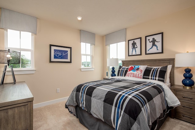 bedroom featuring light carpet and baseboards