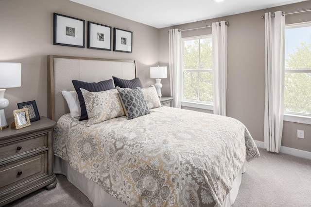bedroom with carpet floors, multiple windows, and baseboards