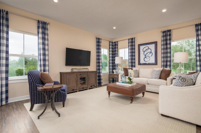 living area with healthy amount of natural light, wood finished floors, baseboards, and recessed lighting