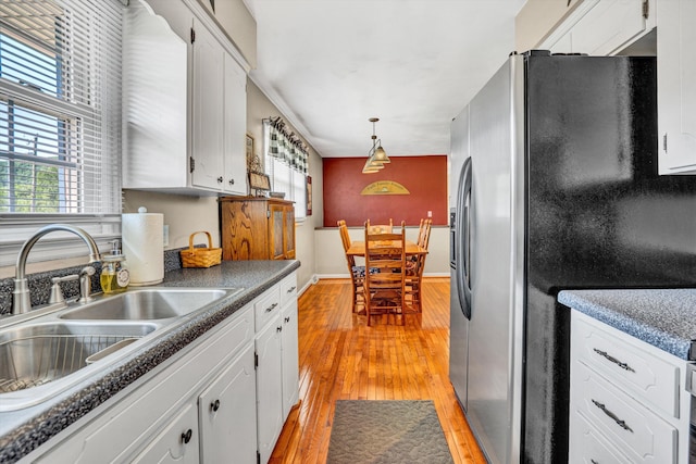 93 SW Ave, Buchanan, VA 24066 - kitchen featuring stainless steel fridge, a sink, light wood-style flooring, white cabinetry, and baseboards