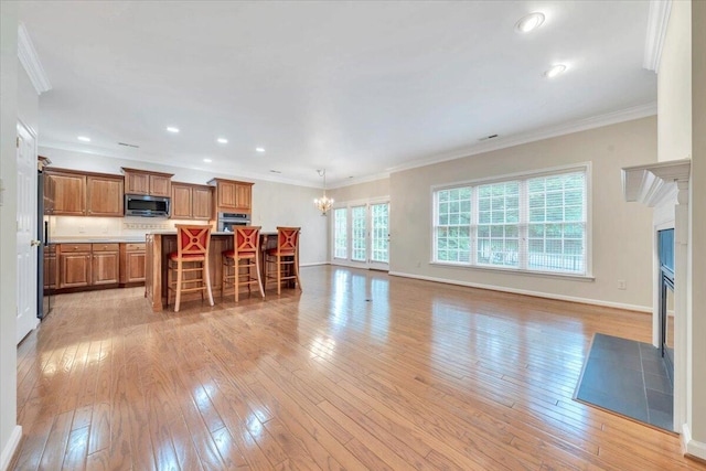 3326 Belshire Ct SW, Roanoke, VA 24014 - kitchen with stainless steel appliances, brown cabinets, a chandelier, light wood-type flooring, and crown molding