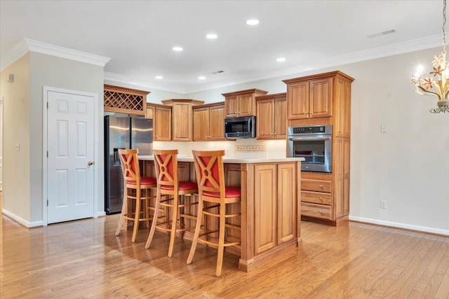 3326 Belshire Ct SW, Roanoke, VA 24014 - kitchen featuring appliances with stainless steel finishes, light countertops, light wood-style flooring, brown cabinets, and crown molding