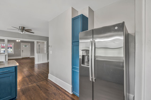 kitchen with stainless steel fridge, blue cabinets, dark wood finished floors, and a ceiling fan