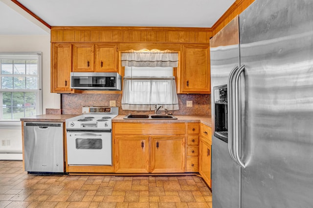 kitchen featuring appliances with stainless steel finishes, a sink, tasteful backsplash, a baseboard heating unit, and light countertops