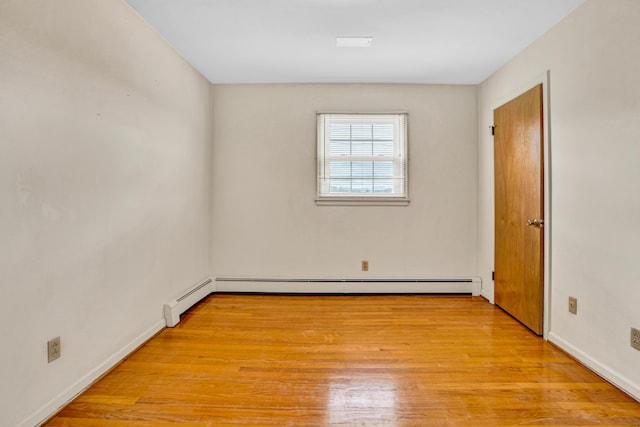 empty room featuring light wood-type flooring and baseboards
