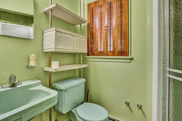 bathroom featuring toilet, a sink, and baseboard heating