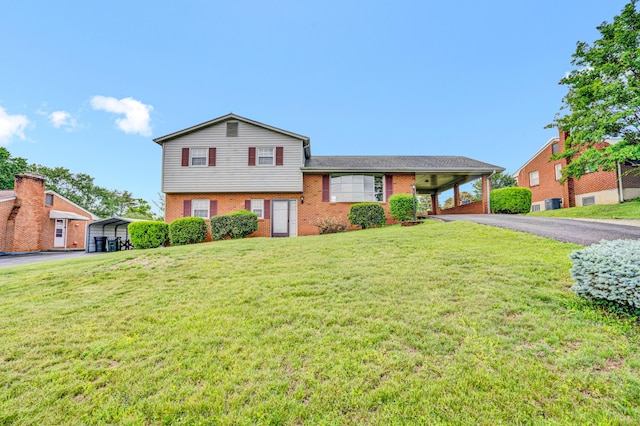 split level home featuring driveway, brick siding, and a front yard