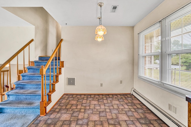 stairs featuring a baseboard heating unit, brick patterned floors, and baseboards