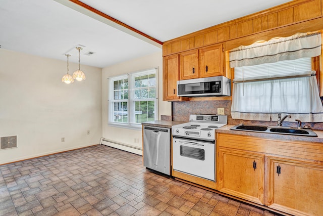 kitchen with appliances with stainless steel finishes, a baseboard heating unit, a sink, baseboards, and brick patterned floors