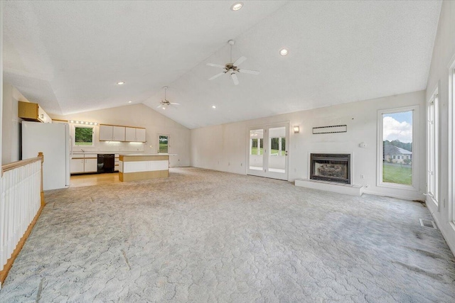 205 Park Shores Cir, Moneta, VA 24121 - unfurnished living room with vaulted ceiling, light colored carpet, a ceiling fan, a glass covered fireplace, and plenty of natural light