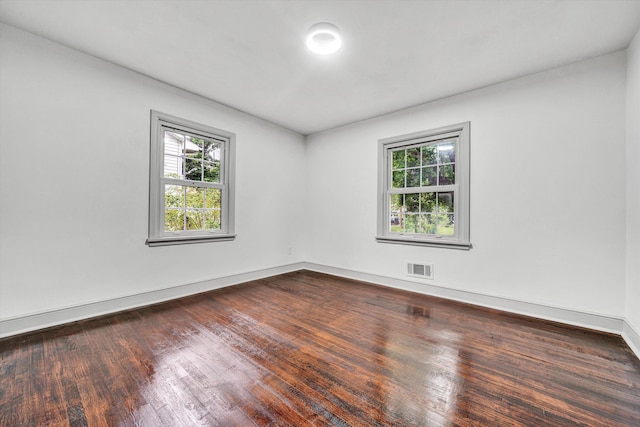 unfurnished room featuring dark wood-type flooring and baseboards