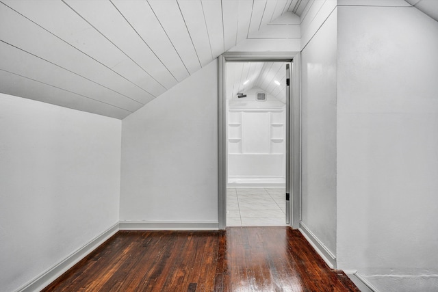 bonus room featuring wood-type flooring, vaulted ceiling, and baseboards
