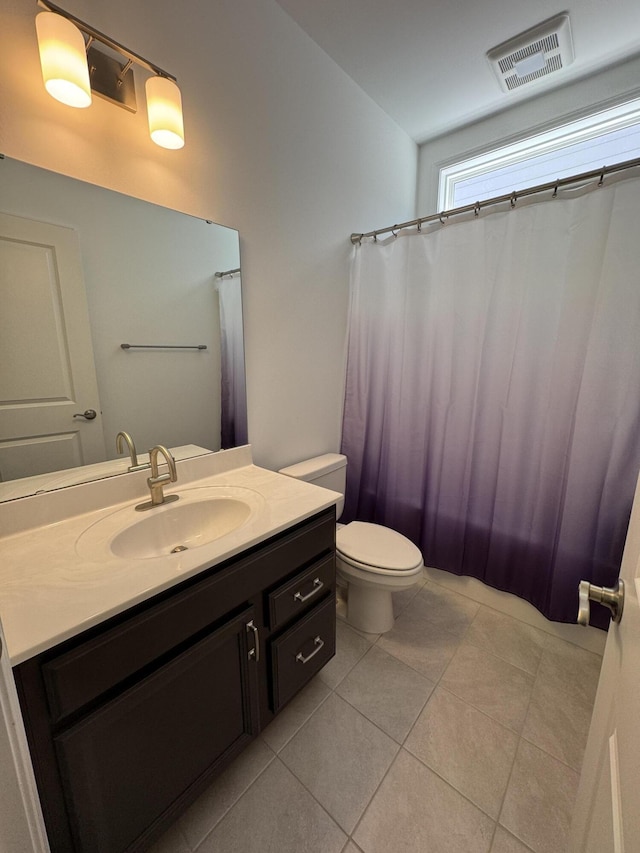 bathroom featuring tile patterned flooring, vanity, and toilet