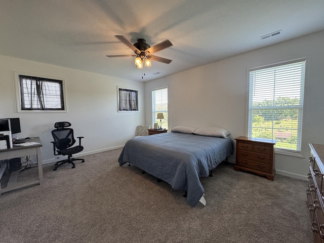 bedroom featuring carpet, an office area, and baseboards