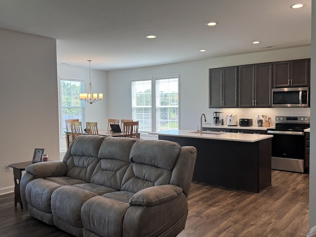 living area with a chandelier, dark wood finished floors, and recessed lighting