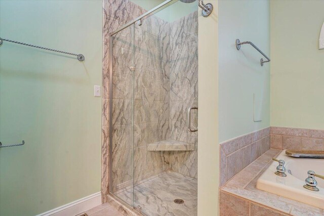 bathroom with a stall shower and a bath