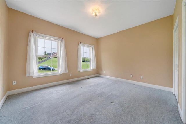 spare room with baseboards and carpet flooring