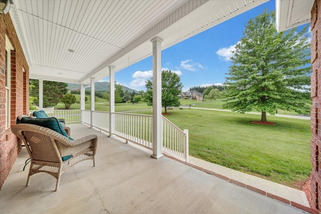 covered porch featuring a lawn