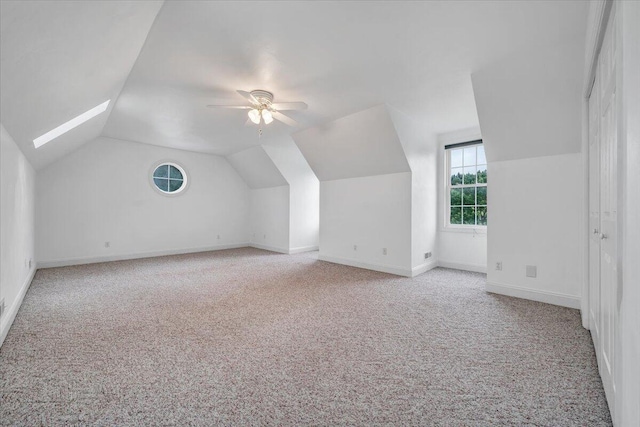additional living space with carpet floors, lofted ceiling, baseboards, and ceiling fan