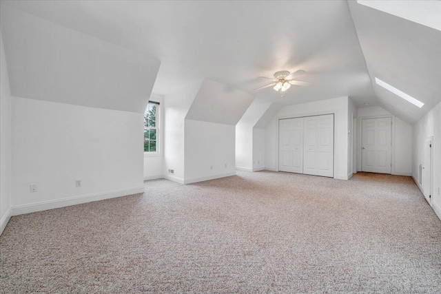 additional living space with vaulted ceiling, carpet flooring, baseboards, and a ceiling fan
