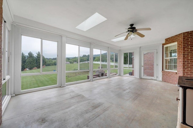 unfurnished sunroom with a skylight, brick wall, and healthy amount of natural light