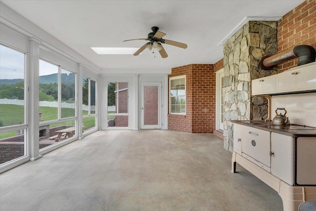 unfurnished sunroom with a skylight and a mountain view