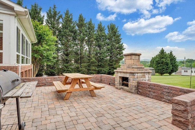 view of patio featuring an outdoor stone fireplace and outdoor dining space