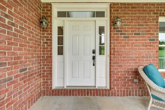 view of exterior entry featuring brick siding