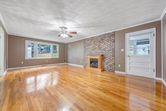 8209 Webster Dr, Roanoke, VA 24019 - unfurnished living room featuring a ceiling fan, light wood-type flooring, crown molding, baseboards, and a brick fireplace