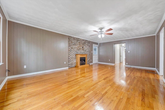 8209 Webster Dr, Roanoke, VA 24019 - unfurnished living room featuring ceiling fan, light wood-style floors, a fireplace, baseboards, and crown molding