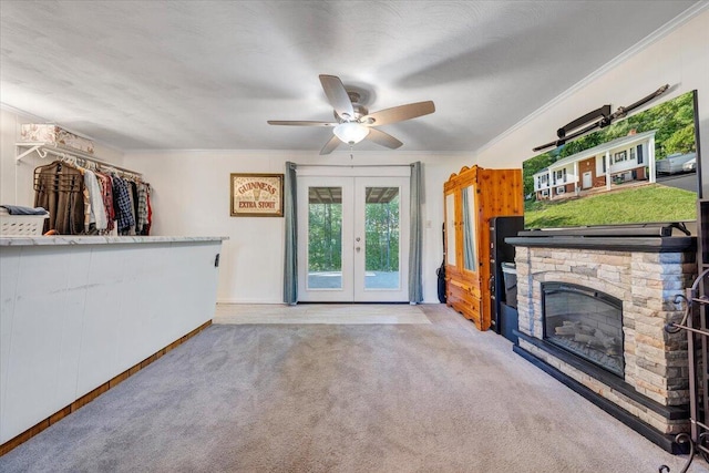 919 Halifax Cir, Vinton, VA 24179 - unfurnished living room with carpet floors, french doors, crown molding, a ceiling fan, and a stone fireplace