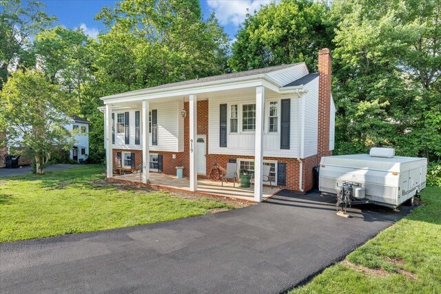 919 Halifax Cir, Vinton, VA 24179 - raised ranch featuring covered porch, a chimney, brick siding, and a front lawn