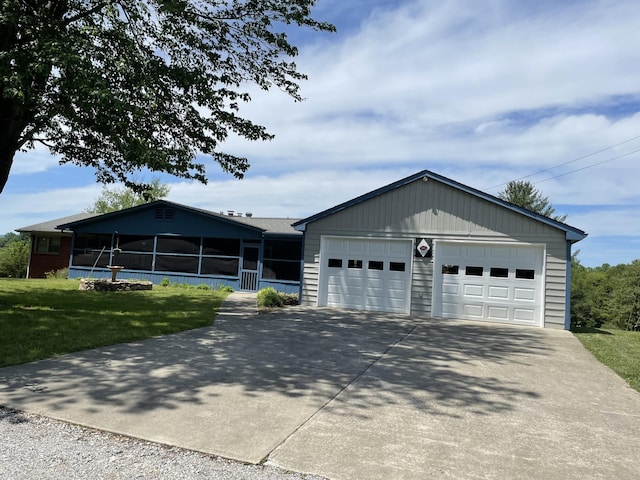 ranch-style home featuring a sunroom, driveway, and a front yard