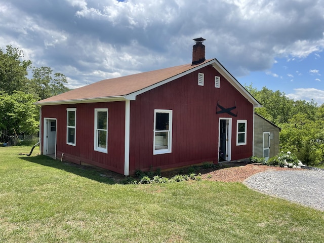 view of front of property with a chimney and a front lawn