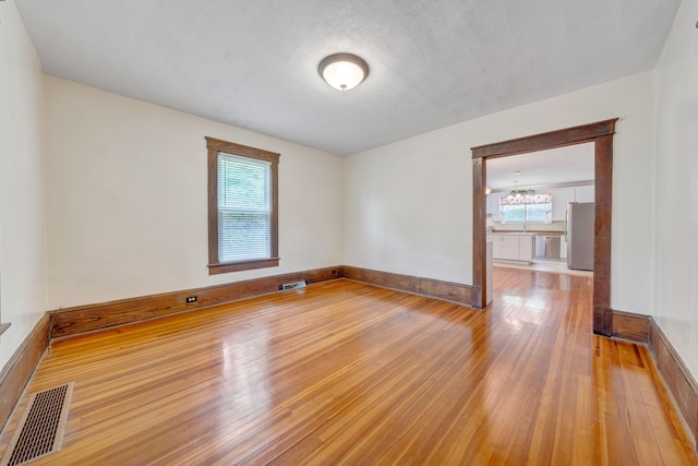 3759 Mill Iron Rd, Goodview, VA 24095 - unfurnished room featuring wood finished floors, a chandelier, and baseboards