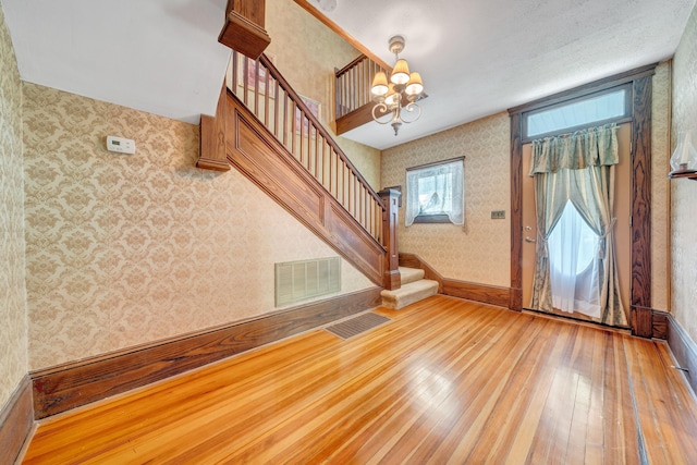 3759 Mill Iron Rd, Goodview, VA 24095 - entryway with wallpapered walls, hardwood / wood-style flooring, stairway, a chandelier, and baseboards