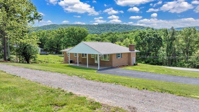 1104 Dolly Ann Dr, Covington, VA 24426 - view of front of house with a chimney, a view of trees, a front yard, and brick siding
