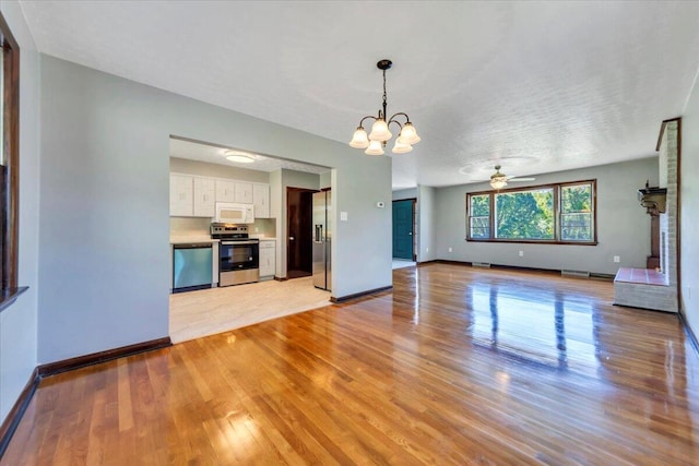 1104 Dolly Ann Dr, Covington, VA 24426 - unfurnished living room with a chandelier, light wood-style floors, a ceiling fan, and baseboards