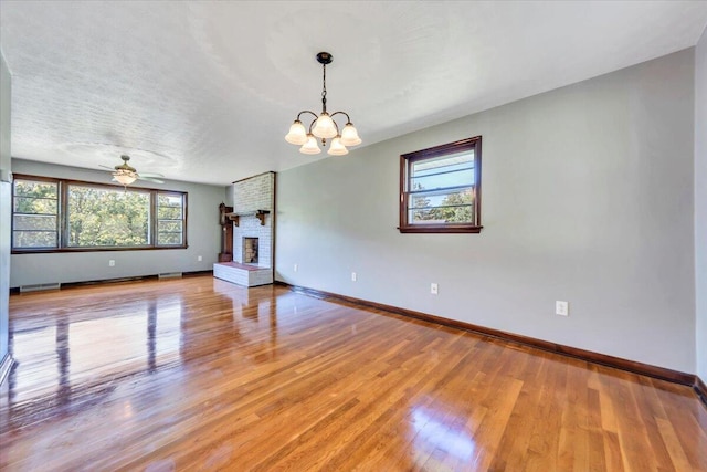 1104 Dolly Ann Dr, Covington, VA 24426 - spare room featuring light wood-style floors, a fireplace, baseboards, and a chandelier